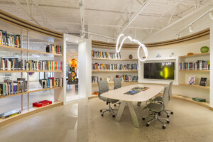 Curving oval walls and open shelving create library area in small art museum